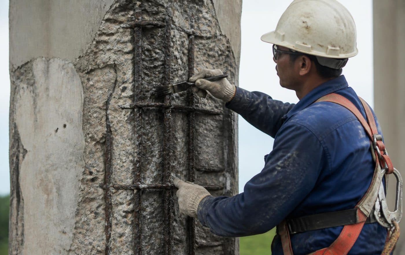 Tratamento de armadura exposta em pilar de concreto armado com escova de aço