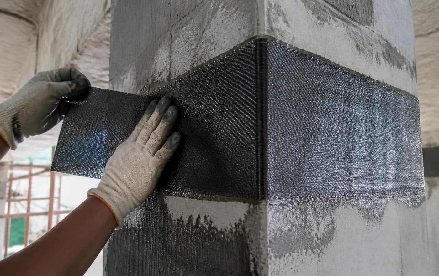 Aplicação de manta de fibra de carbono no reforço de um pilar de concreto
